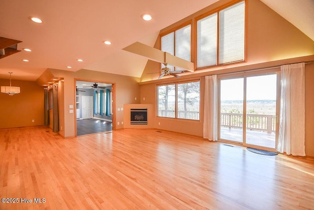 unfurnished living room with ceiling fan, light hardwood / wood-style flooring, and lofted ceiling