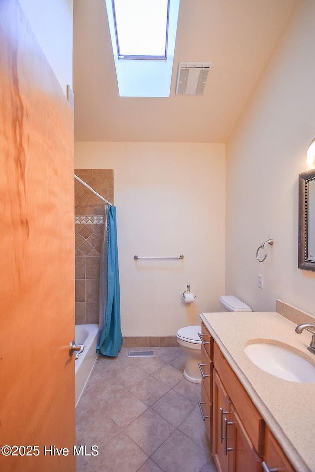 full bathroom featuring toilet, tile patterned flooring, shower / tub combo with curtain, a skylight, and vanity