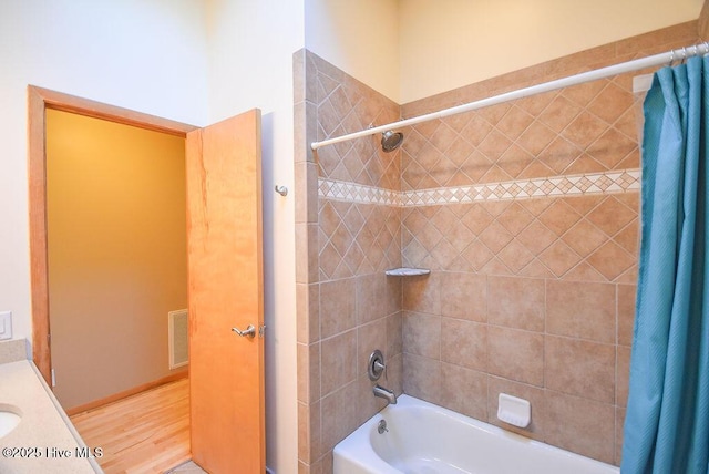 bathroom featuring hardwood / wood-style floors, shower / bath combination with curtain, and vanity