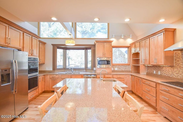 kitchen featuring light stone countertops, appliances with stainless steel finishes, and a breakfast bar area