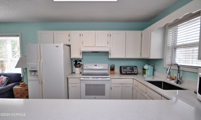 kitchen with white cabinets, sink, plenty of natural light, and white appliances