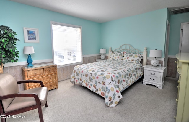 carpeted bedroom featuring wood walls