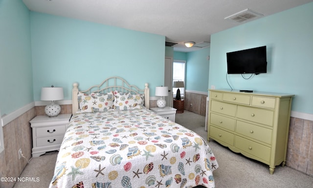 carpeted bedroom featuring wooden walls