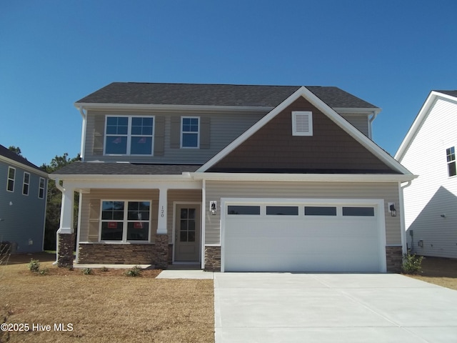 craftsman-style house featuring stone siding, driveway, and an attached garage