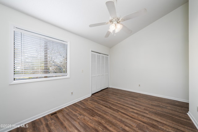 unfurnished bedroom featuring visible vents, baseboards, lofted ceiling, wood finished floors, and a closet