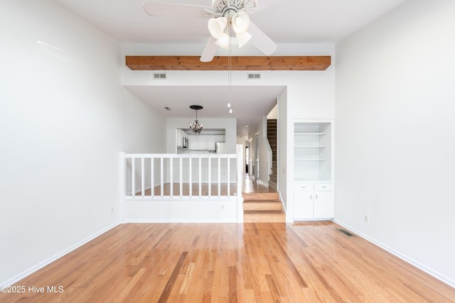 spare room with light wood finished floors, baseboards, stairs, and visible vents