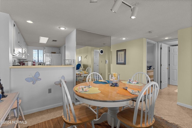 dining room featuring a textured ceiling and light tile patterned floors