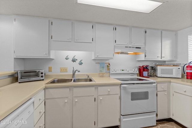 kitchen with white appliances, white cabinetry, and sink