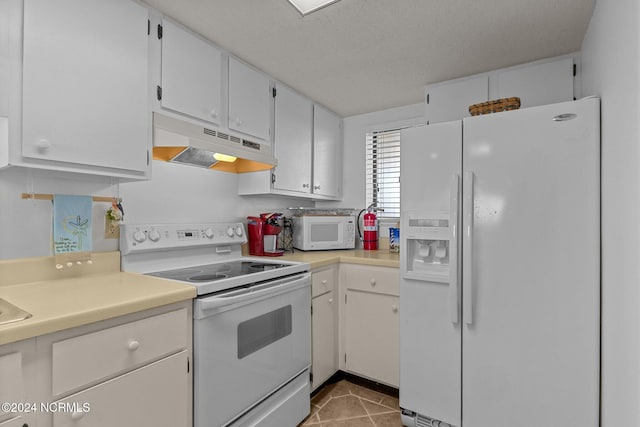 kitchen featuring white cabinets, a textured ceiling, and white appliances