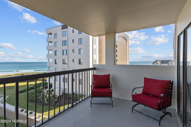 balcony featuring a view of the beach and a water view