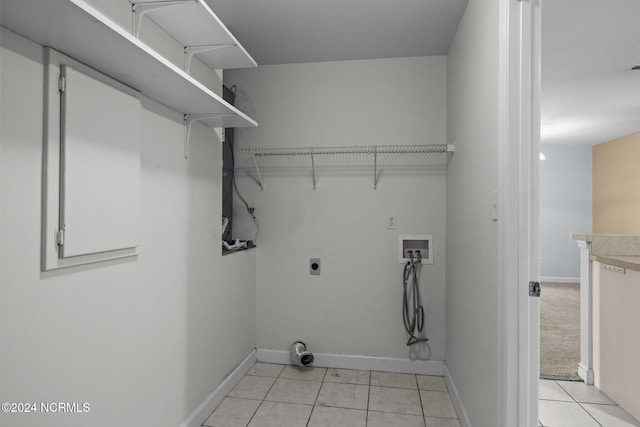 clothes washing area with hookup for an electric dryer, hookup for a washing machine, and light tile patterned floors