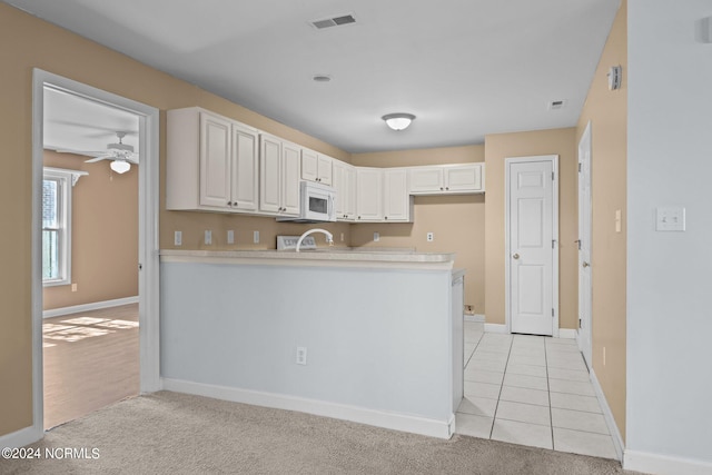 kitchen featuring white cabinetry, light carpet, kitchen peninsula, and ceiling fan