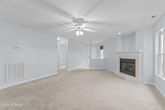 unfurnished living room with light colored carpet, ceiling fan, and a fireplace