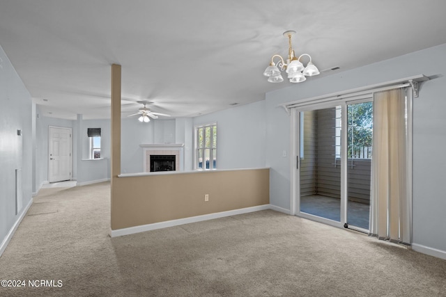 unfurnished living room with a tiled fireplace, light carpet, and ceiling fan with notable chandelier