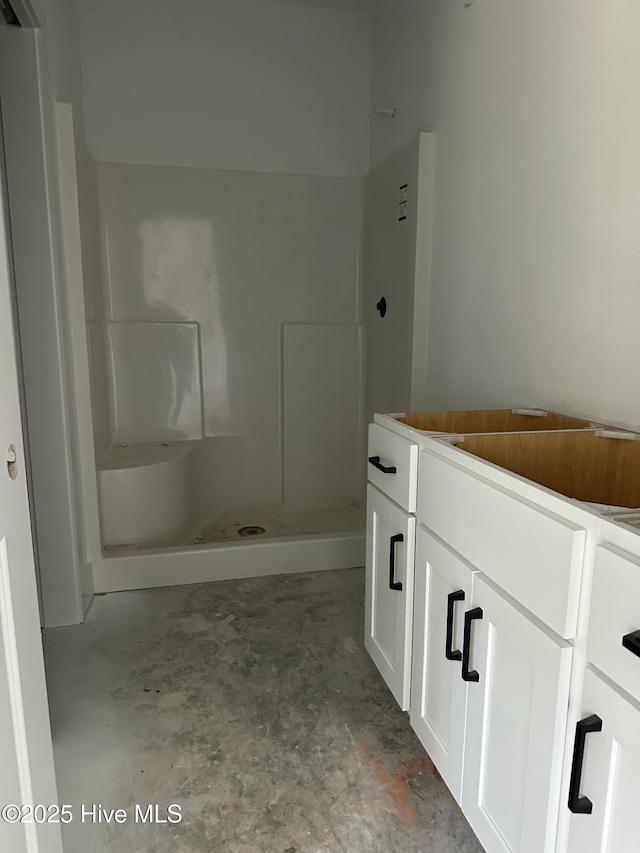 bathroom featuring a stall shower and unfinished concrete flooring