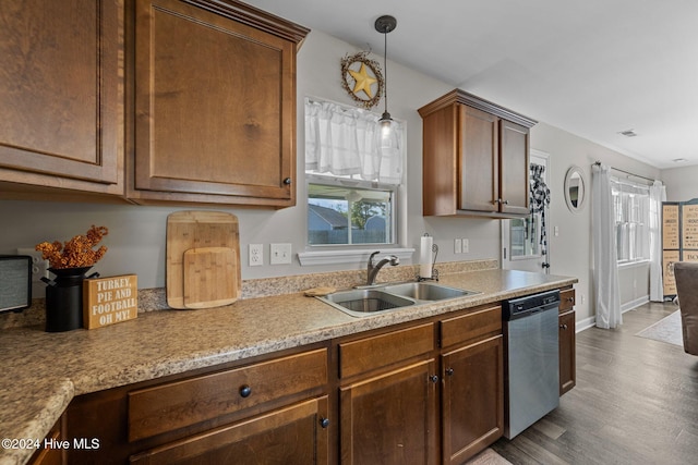 kitchen featuring pendant lighting, sink, stainless steel dishwasher, and hardwood / wood-style flooring