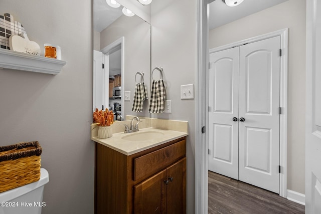 bathroom with vanity, toilet, and wood-type flooring