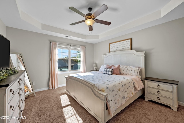 bedroom featuring carpet floors, a raised ceiling, and ceiling fan