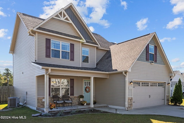 craftsman-style house with a porch, a garage, a front yard, and central AC