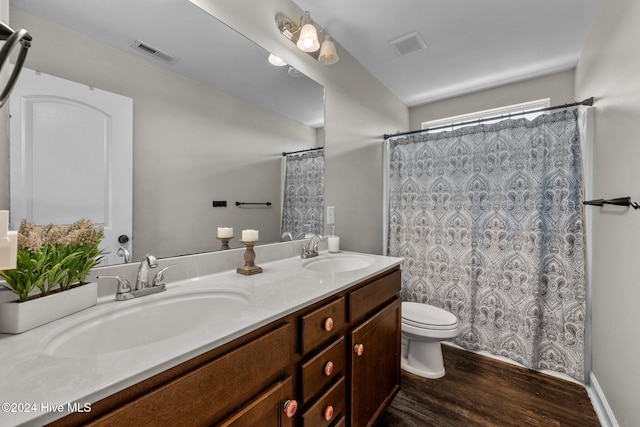 bathroom with curtained shower, vanity, wood-type flooring, and toilet