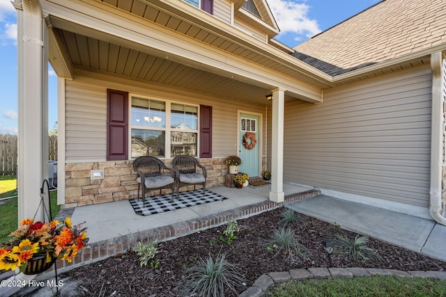 view of exterior entry featuring covered porch