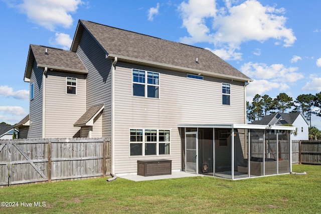 rear view of property with a yard, a patio area, and a sunroom