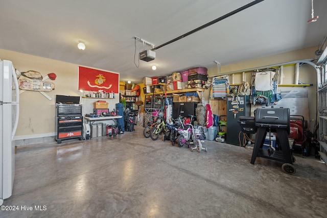 garage featuring white fridge and a garage door opener