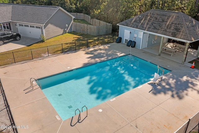 view of swimming pool featuring a yard, a patio, and an outdoor structure