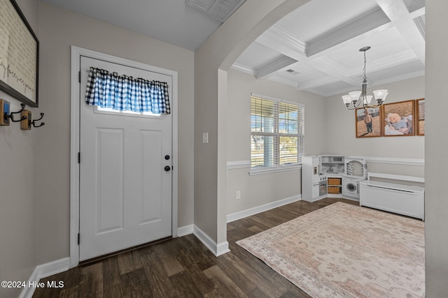 foyer entrance with coffered ceiling, dark hardwood / wood-style floors, ornamental molding, beamed ceiling, and a notable chandelier