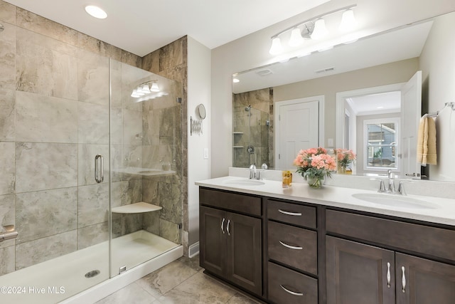 bathroom featuring a shower with door and vanity