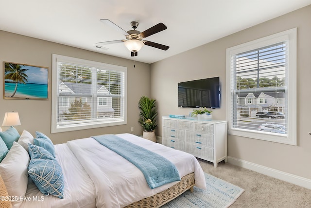 carpeted bedroom with multiple windows and ceiling fan