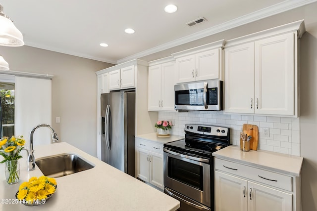 kitchen with sink, crown molding, appliances with stainless steel finishes, tasteful backsplash, and white cabinets