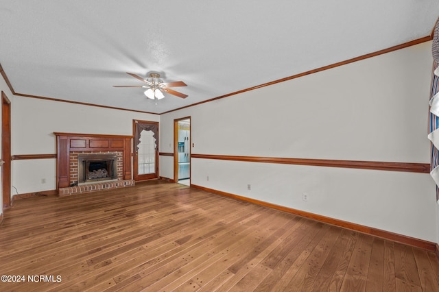 unfurnished living room with crown molding, a brick fireplace, and hardwood / wood-style flooring