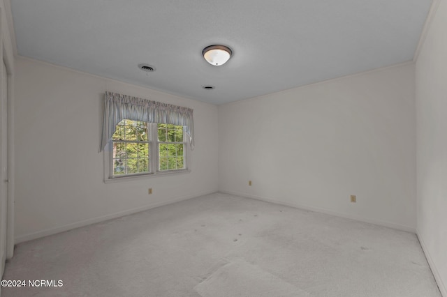 carpeted spare room with crown molding