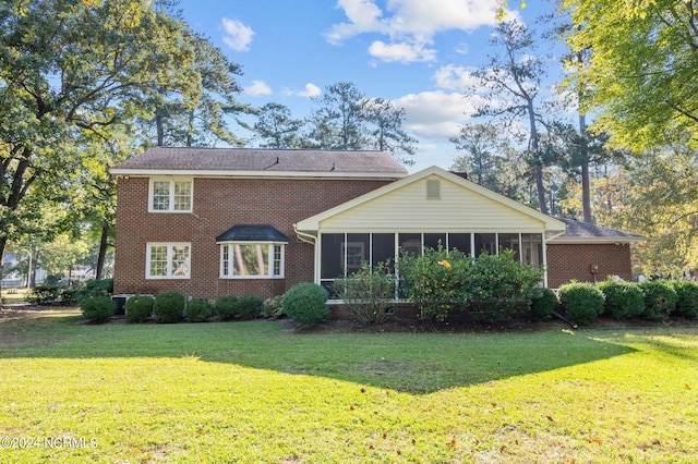 back of property featuring a yard and a sunroom