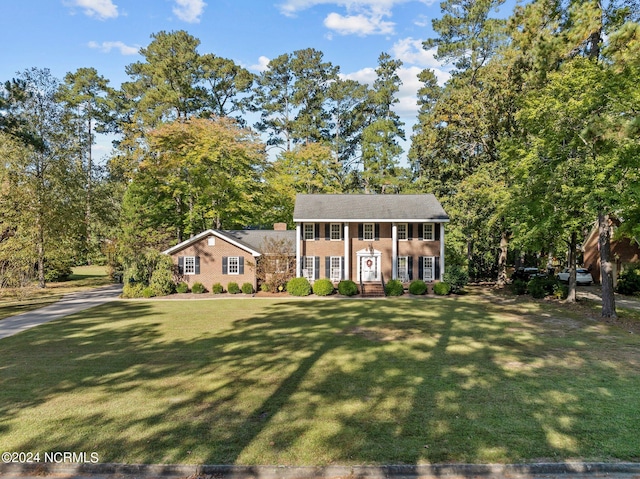 colonial inspired home with a front lawn