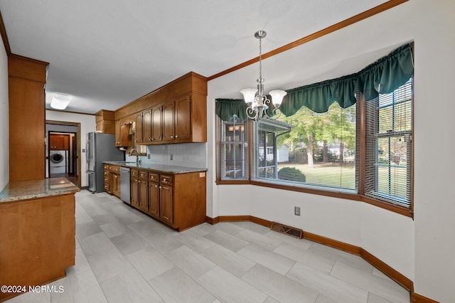 kitchen featuring sink, appliances with stainless steel finishes, a healthy amount of sunlight, and washer / clothes dryer