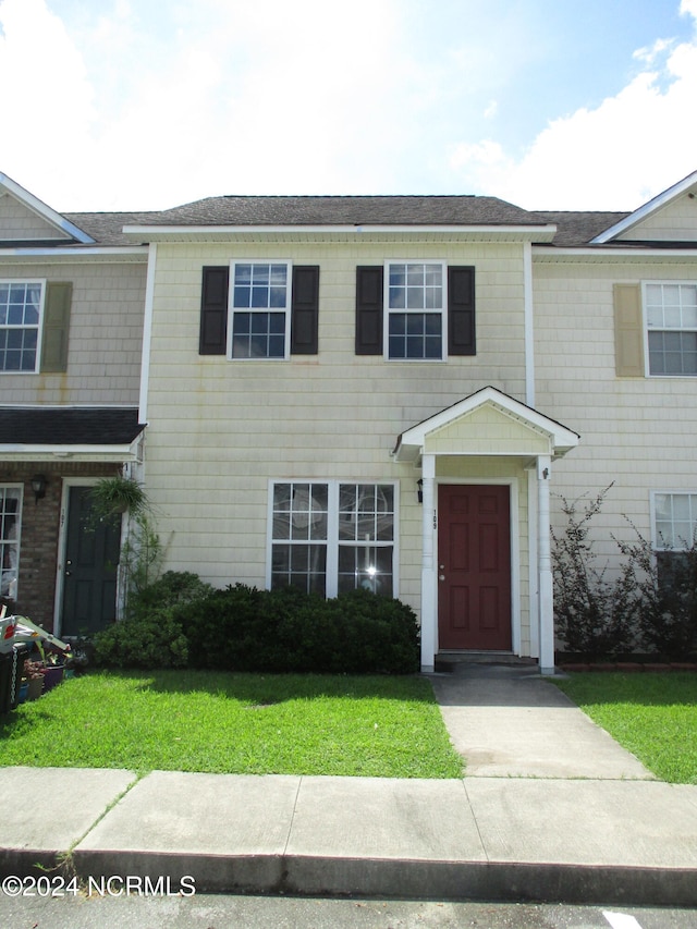 multi unit property featuring a front lawn