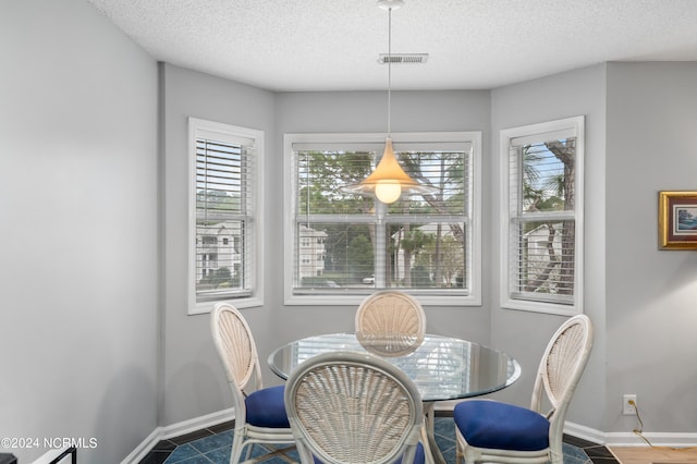 dining room featuring a textured ceiling and wood-type flooring