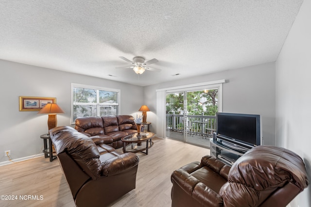 living room featuring a textured ceiling, light hardwood / wood-style floors, and ceiling fan