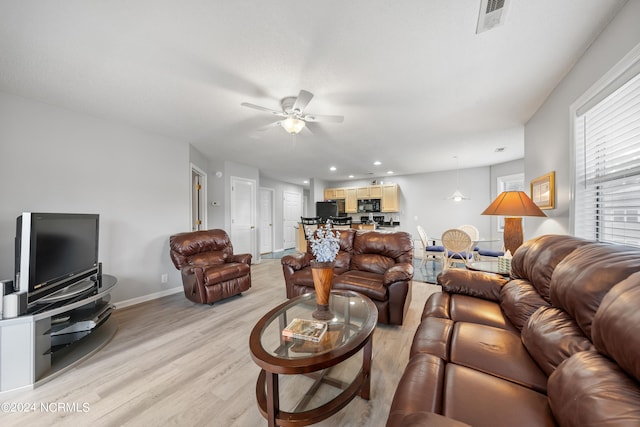 living room featuring light wood-type flooring and ceiling fan