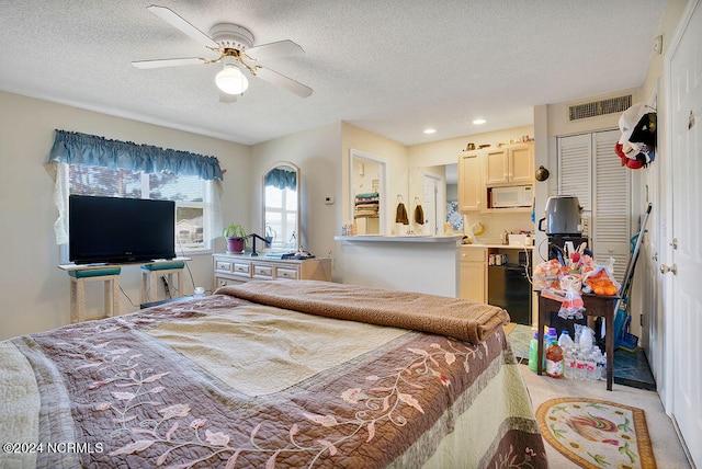 carpeted bedroom featuring a closet, ceiling fan, and a textured ceiling