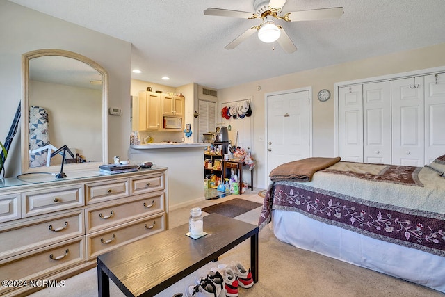 carpeted bedroom featuring a textured ceiling and ceiling fan