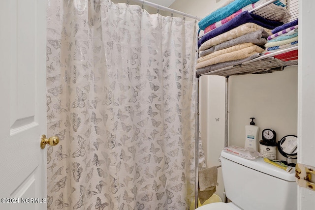 bathroom with toilet and curtained shower