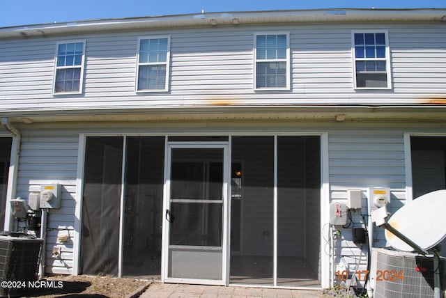 rear view of house featuring a sunroom and cooling unit