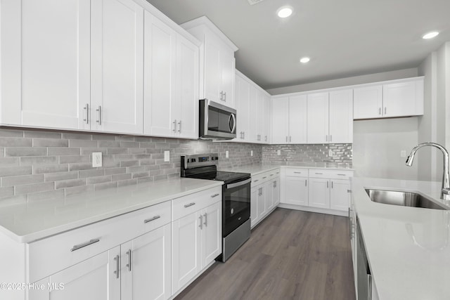 kitchen with white cabinets, appliances with stainless steel finishes, decorative backsplash, and sink