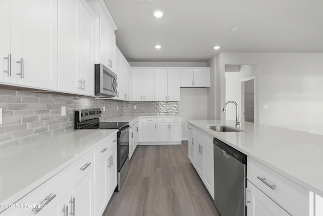 kitchen with decorative backsplash, sink, white cabinetry, and stainless steel appliances