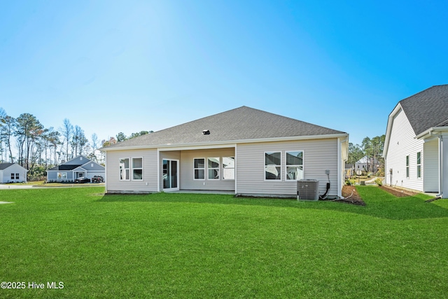 rear view of house featuring a lawn and cooling unit