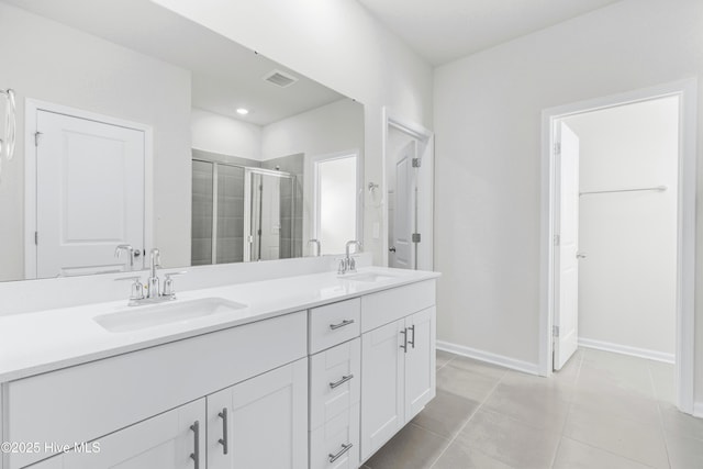 bathroom featuring tile patterned flooring, vanity, and an enclosed shower