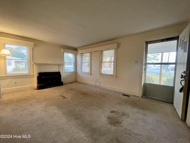 unfurnished living room with light carpet and a healthy amount of sunlight